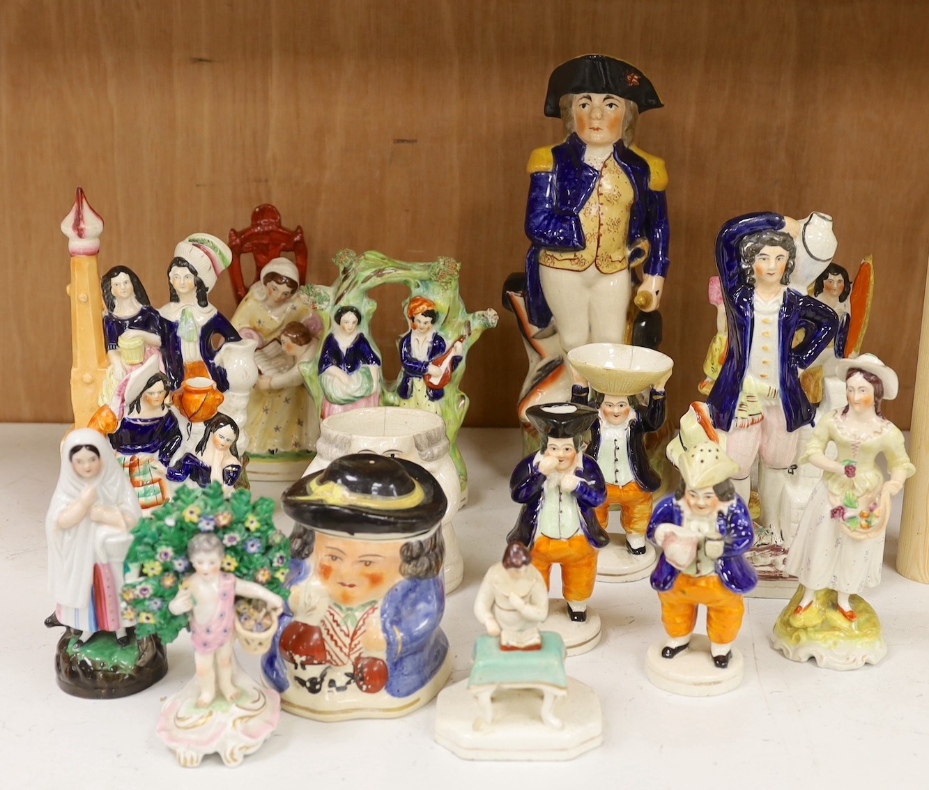A large group of Staffordshire pottery figures and groups and figural cruets, to include a Nelson commemorative Toby jug, 31 cms high.